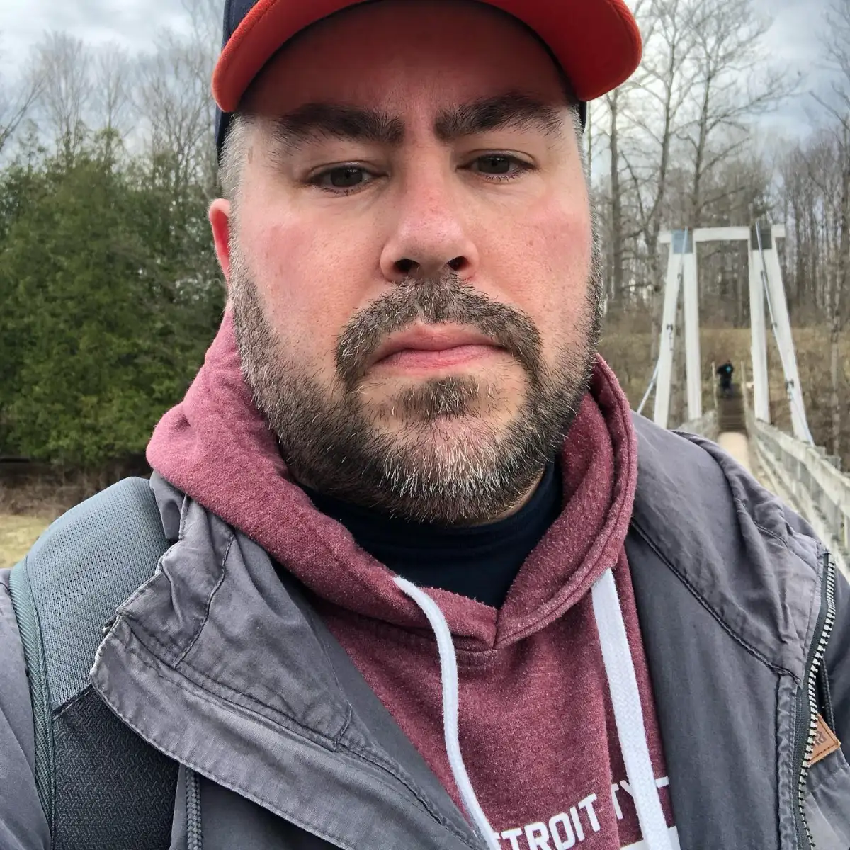 Headshot of Nate Dorough, A middle aged man with a medium beard wearing a hoodie and hat.