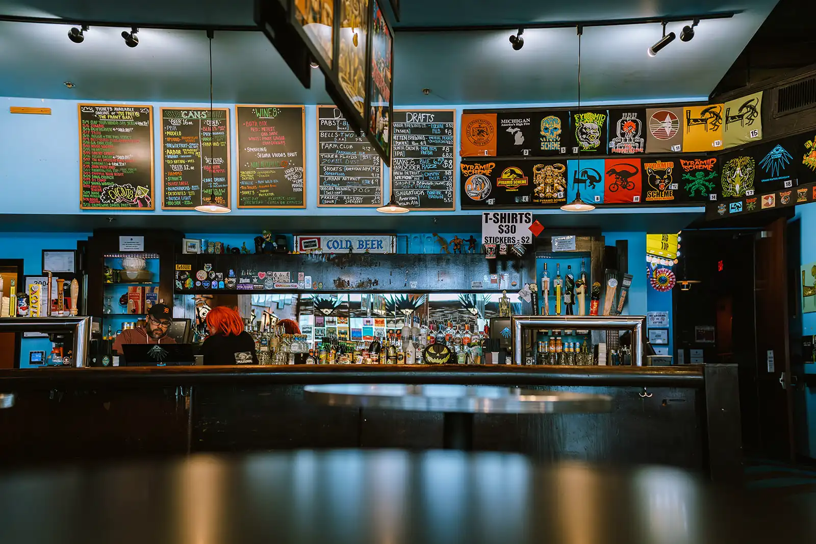 wide angle view of bar with menus, shirts, and drinks